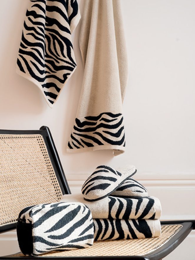 Toallas animal prime zebra Toallas y mantas de diseño a rayas en blanco y negro sobre una silla.