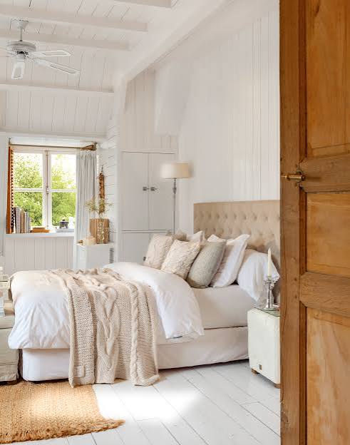 Dormitorio luminoso y acogedor con cama elegante y decoración neutra.