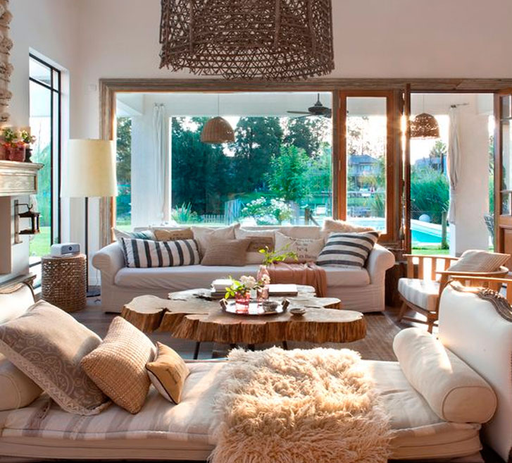 Canela Sala de estar luminosa con sofá cómodo, mesa de madera y vistas al jardín.