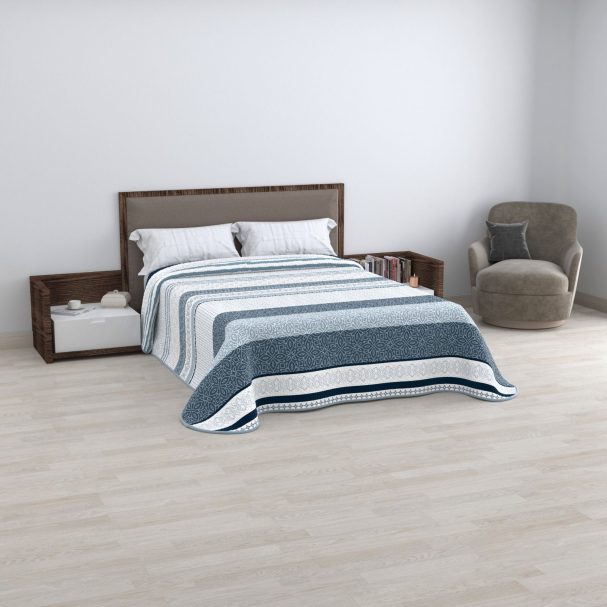 Cama doble con edredón a rayas y sillón en habitación minimalista.