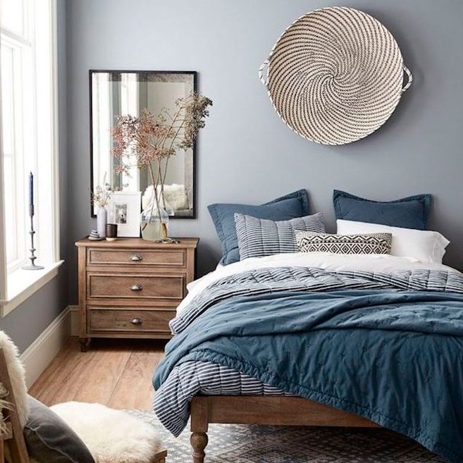 Salon en tonos azules ropa de hogar carla Habitación con cama grande, paredes azules, mesita de noche y decoración elegante.