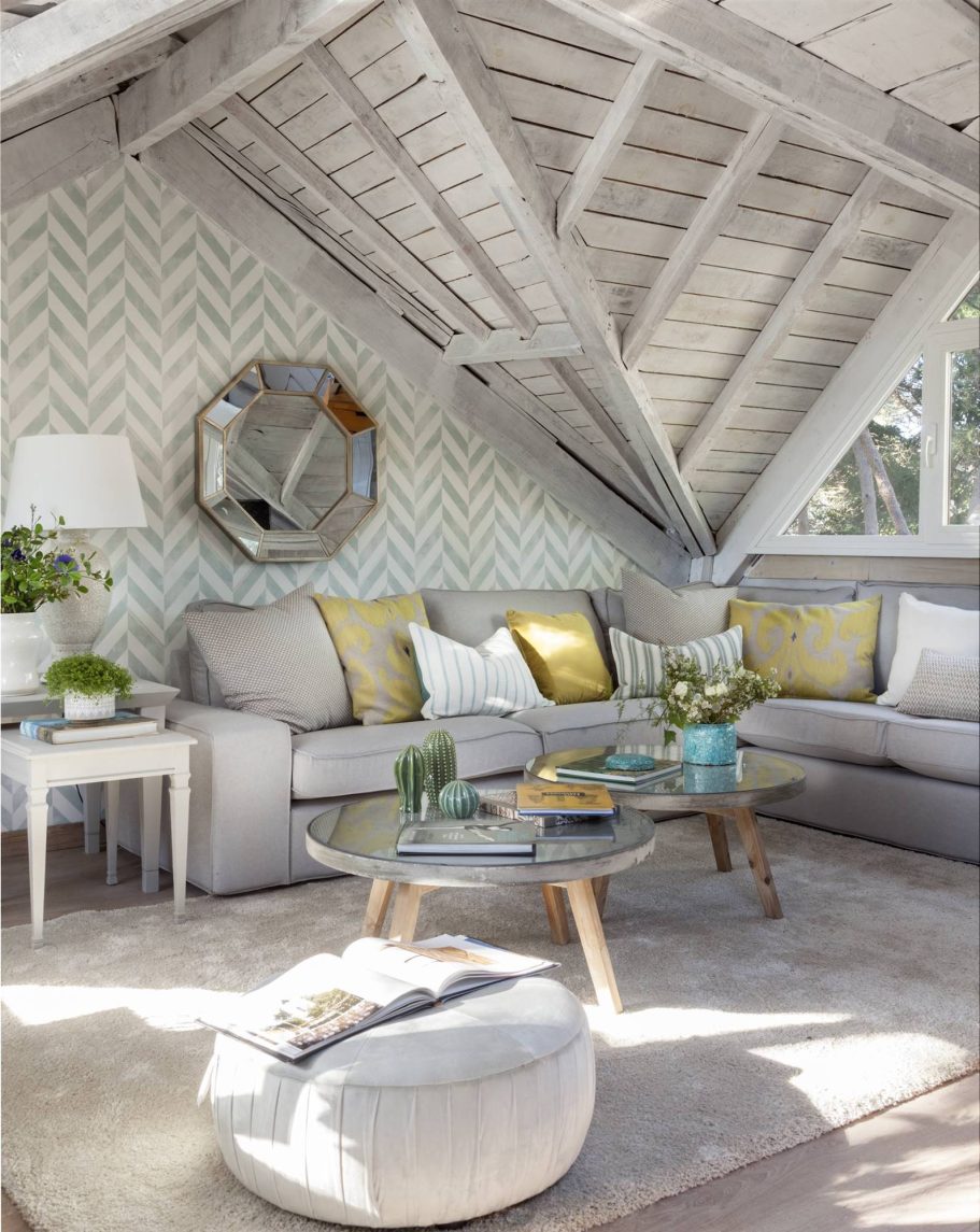 Gris Salón moderno con techo inclinado, muebles claros y decoración en tonos suaves.