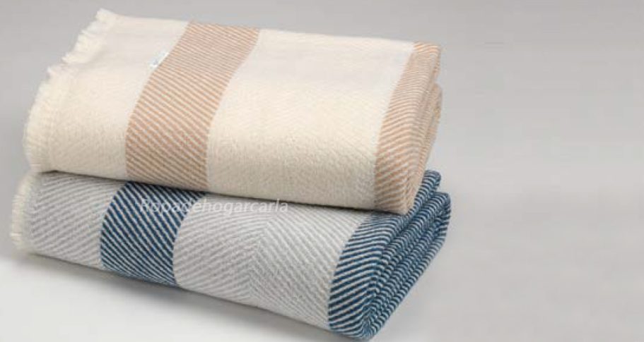 Multiusos Toallas de algodón, una blanca y otra en tonos azul y gris, apiladas sobre superficie clara.