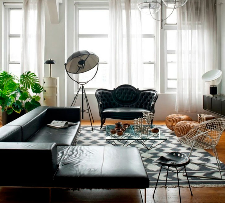 Blanco y Negro Sala moderna con sofá negro, sillón elegante, plantas y luz natural.