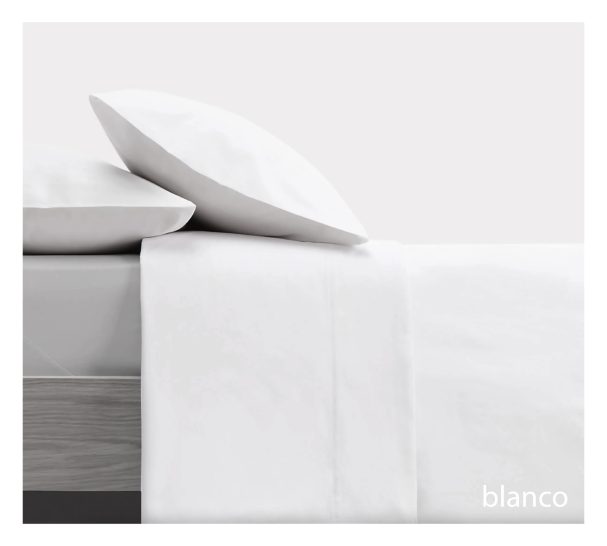 Sábanas blancas sobre una cama con cojines, fondo blanco.