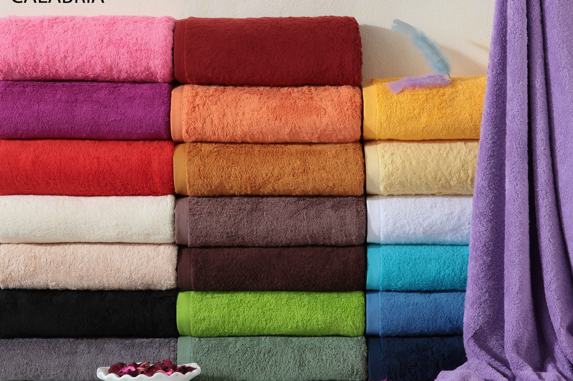 Toallas de colores apiladas en una superficie, ropa de baño