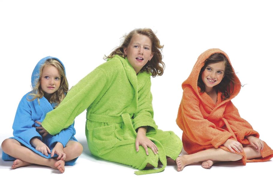 Albornoz de niño Trovador Tres niñas sentadas en el suelo, vestidas con batas de baño de colores brillantes.